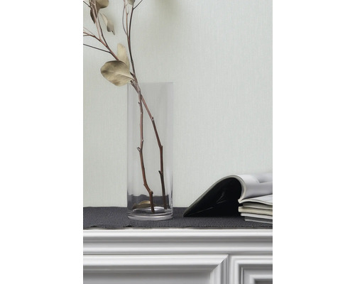 Dekorative Zweige in Glasvase und Zeitschriften auf einem Regal