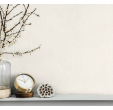 Arrangement décoratif avec vase, branches fleuries, horloge de table et fleur de lotus séchée sur une étagère.