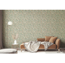 Wohnzimmer mit floral gemusterter Tapete, Sofa und Stehlampe.