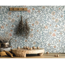 Scène avec papier peint fleuri, tabouret en bois, plante en pot et crochet mural avec herbes