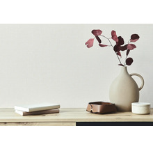 Décoration avec vase, fleurs séchées, pile de livres et boîte de rangement sur une table