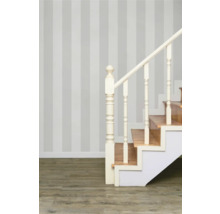 Treppe mit Holzstufen und weißem Geländer vor gestreifter Wand