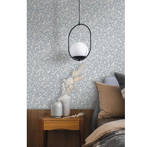 Chambre avec papier peint à motifs de feuilles, table de chevet et lampe