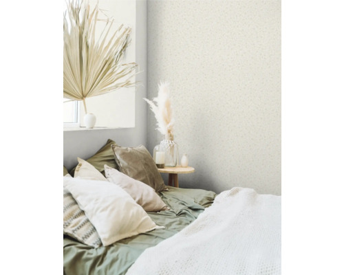 Schlafzimmer mit gemusterter Tapete, Bett mit Kissen und Dekorationsgegenständen.