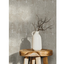 Papier peint à motif d''arbres sur un mur, avec un vase blanc contenant des branches sur un tabouret en bois