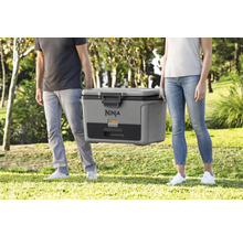 Zwei Personen tragen eine tragbare Ninja Kühlbox im Freien.