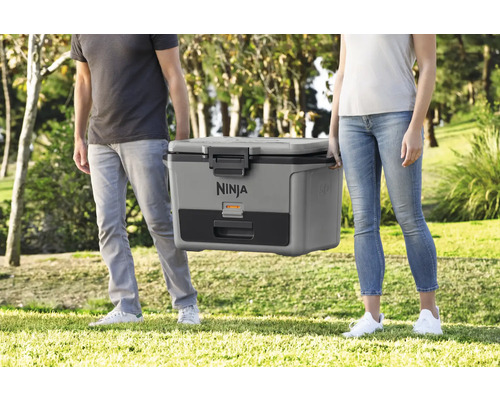 Zwei Personen tragen eine tragbare Ninja Kühlbox im Freien.
