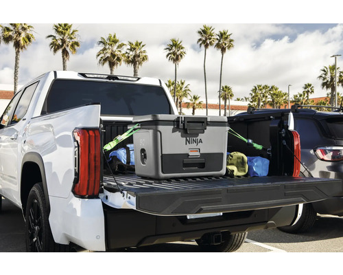 Ein grauer Ninja Kühler befindet sich auf der Ladefläche eines weißen Pick-up-Trucks, befestigt mit Gurten.
