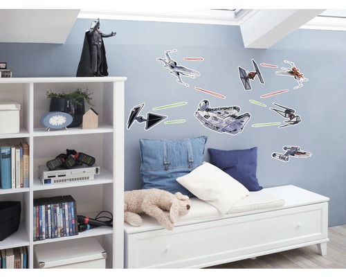 Chambre d''enfant avec stickers muraux Star Wars de vaisseaux spatiaux et figurine Dark Vador sur une étagère.