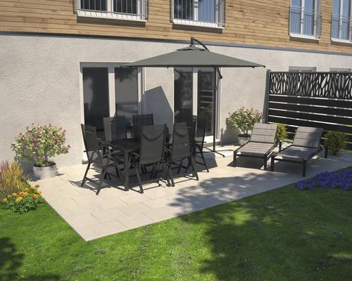 Gartenszene mit Esstisch, Stühlen, Sonnenschirm und Gartenliegen auf einer Terrasse