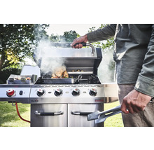 Grill en acier inoxydable avec des aliments et une personne faisant des grillades