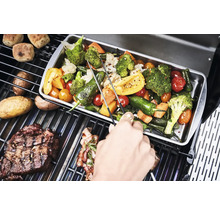 Des légumes et des steaks préparés sur un grill.