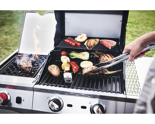 Barbecue en acier inoxydable avec des aliments grillés comme de la viande et des légumes