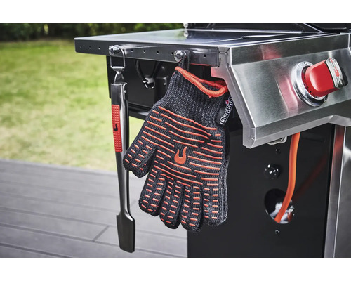 Pince de barbecue et gant de barbecue accrochés à un barbecue
