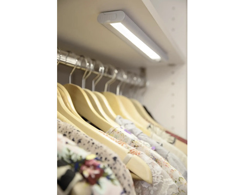 LED-Leuchte im Kleiderschrank mit Kleiderbügeln und Kleidung.