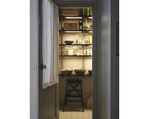 Aperçu d''un cellier avec des étagères remplies de nourriture et de provisions, éclairées par des bandes LED, avec une échelle pour l''accès