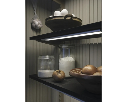 Étagère avec des aliments : œufs, ail, oignons, farine dans des bocaux et des bols