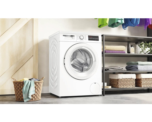 Lave-linge pose libre avec panier à linge et étagère en arrière-plan