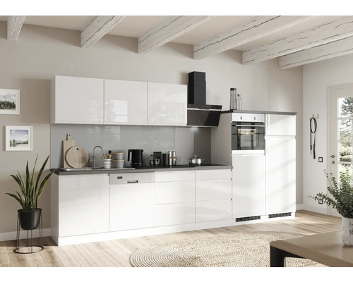 Cuisine lumineuse avec armoires blanches, hotte aspirante et divers ustensiles de cuisine