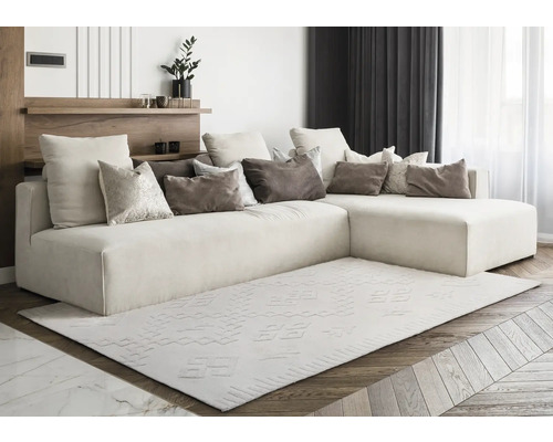 Salon lumineux avec canapé d''angle, coussins et tapis à motifs