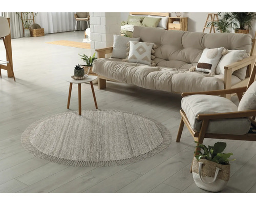 Salon avec tapis rond, canapé et fauteuil en bois