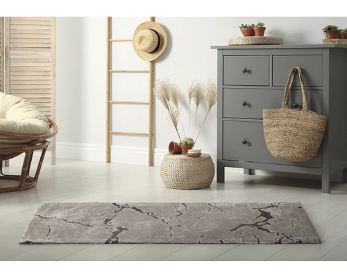 Salon avec tapis gris, commode et décorations