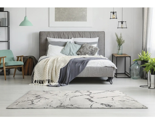 Chambre lumineuse avec lit, tapis et décorations pour une ambiance conviviale.