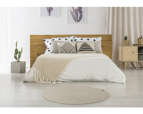 Chambre à coucher avec lit en bois, coussins à motifs, couvre-lit et tapis rond