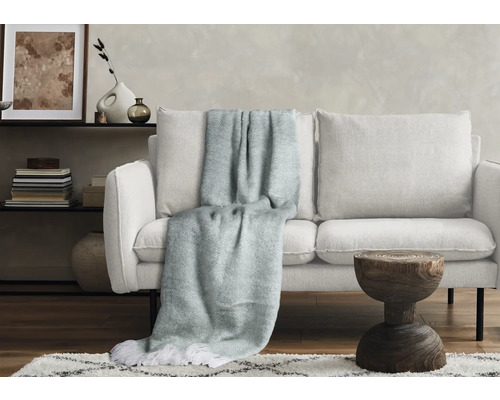 Salon avec canapé blanc, couverture à franges et table d''appoint en bois