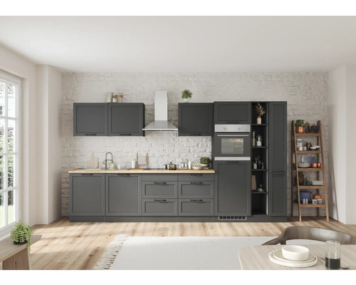 Cuisine moderne avec armoires grises, plan de travail en bois et appareils en acier inoxydable devant un mur en briques.