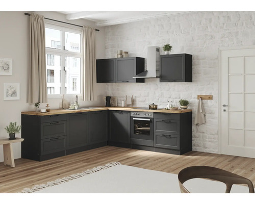 Cuisine moderne avec armoires grises, surfaces en bois et appareils devant un mur de briques.