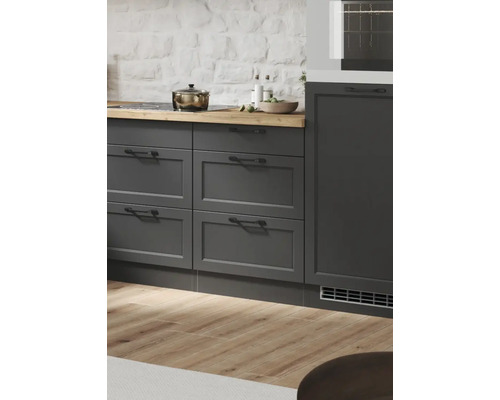 Scène de cuisine avec armoires grises, plaque de cuisson et plan de travail en bois