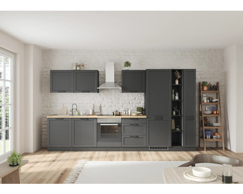 Cuisine grise avec armoires murales, évier et appareils électroménagers sur un mur de briques blanches