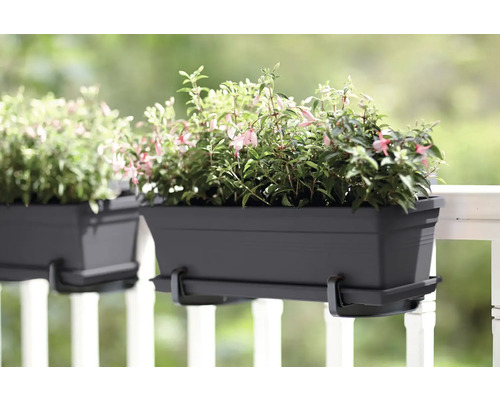 Zwei graue Balkonkästen mit Halterung und Pflanzen auf einem Balkon.