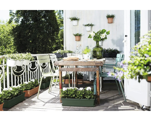 Balcon accueillant avec table, chaises et jardinières fleuries
