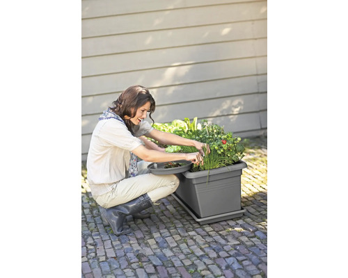 Frau arbeitet im Garten mit einem Pflanzkasten