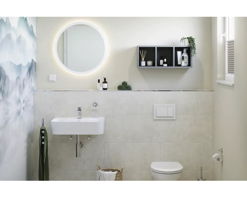 Badezimmer mit Waschtisch, beleuchtetem Spiegel, Regal und Toilette.