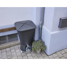 Regentonne mit Deckel, Wasserhahn und Gießkanne vor Hauswand