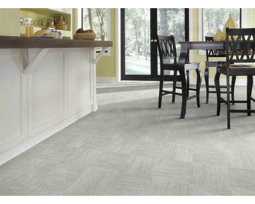 Pièce lumineuse avec carrelage au sol en damier et îlot de cuisine avec tabourets de bar