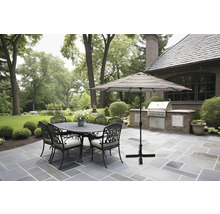 Gartenszene mit Esstisch, Stühlen, Sonnenschirm und Grill im Freien.
