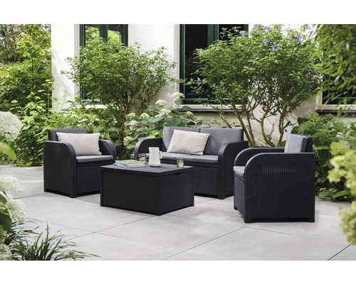 Ensemble de meubles de jardin avec deux fauteuils, un canapé deux places et une table avec espace de rangement sur une terrasse