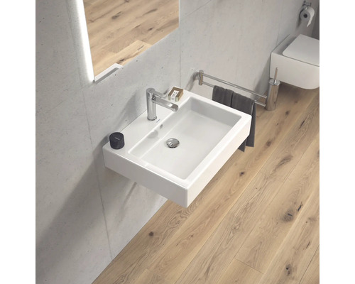 Badezimmer mit rechteckigem, wandhängendem Waschbecken, Armatur und Handtuchhalter