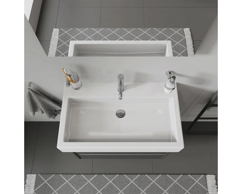 Photo d''un lavabo blanc avec robinet, distributeur de savon et porte-serviettes dans la salle de bain