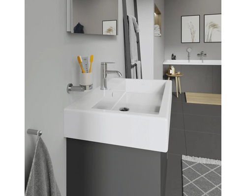 Salle de bains moderne avec lavabo, robinet, miroir et porte-serviettes.