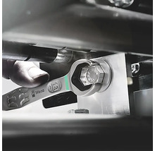 Un homme utilise une clé mixte Wera pour serrer une vis.