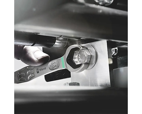 Un homme utilise une clé mixte Wera pour serrer une vis.