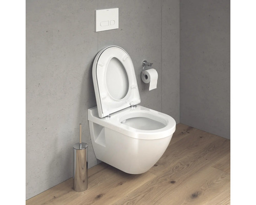 WC suspendu avec couvercle de toilette ouvert, réservoir de chasse d''eau et porte-papier toilette dans la salle de bain.