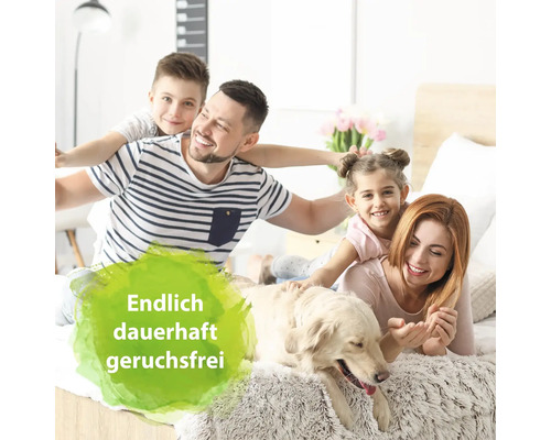 Eine Familie liegt mit einem Hund auf einem Bett.