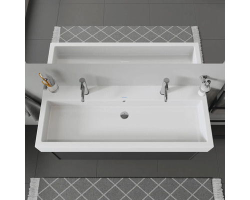 Lavabo double avec deux robinets, distributeur de savon et gobelet à brosse à dents dans la salle de bain