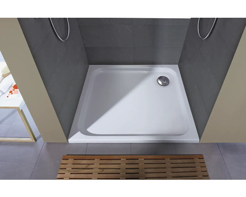 Quadratische Duschwanne aus Mineralguss in einer grauen Duschkabine mit Holzrost.